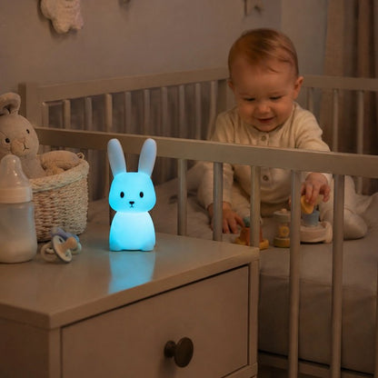bébé joue dans son lit a coté du Veilleuse lapin bleu
