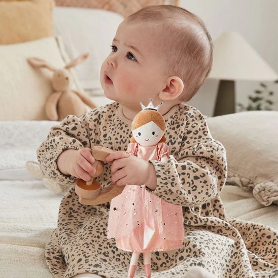 Bébé tient son doudou dans ce bras