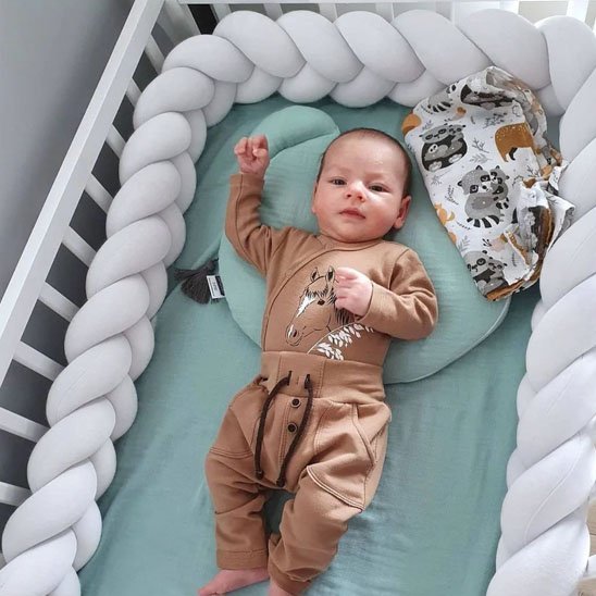bébé entourer par tresse de lit